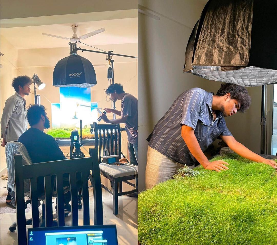 Crew placing grass on the miniature set under studio lights