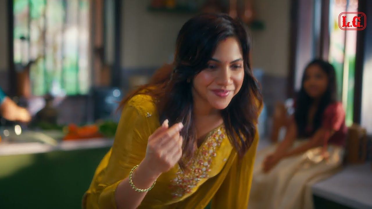 A woman smiling in a kitchen, from the LG Hing commercial